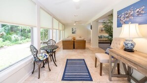 A sunlit room with a dining table, chairs, and a sofa. - Fairway Oaks 3209 (Fernandina Beach)