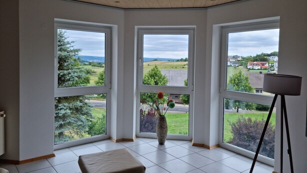 A room with three large windows, a wooden ceiling, and a tiled floor. - Ferienwohnung "schöne Aussicht" in der Rhön (Kalbach)