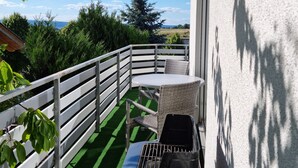 A balcony with a grill, outdoor furniture, and a view of the landscape. - Ferienwohnung "schöne Aussicht" in der Rhön (Kalbach)