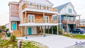 Een woonhuis met twee verdiepingen, een balkon, een garage en een oprit.