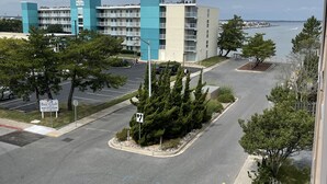 Ein mehrstöckiges Hotel mit blau-beiger Fassade in der Nähe eines Wasserufers.
