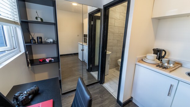 A compact kitchen with a microwave, coffee maker, and a small dining area. - Cosy Studio Close to University of Birmingham (Birmingham)