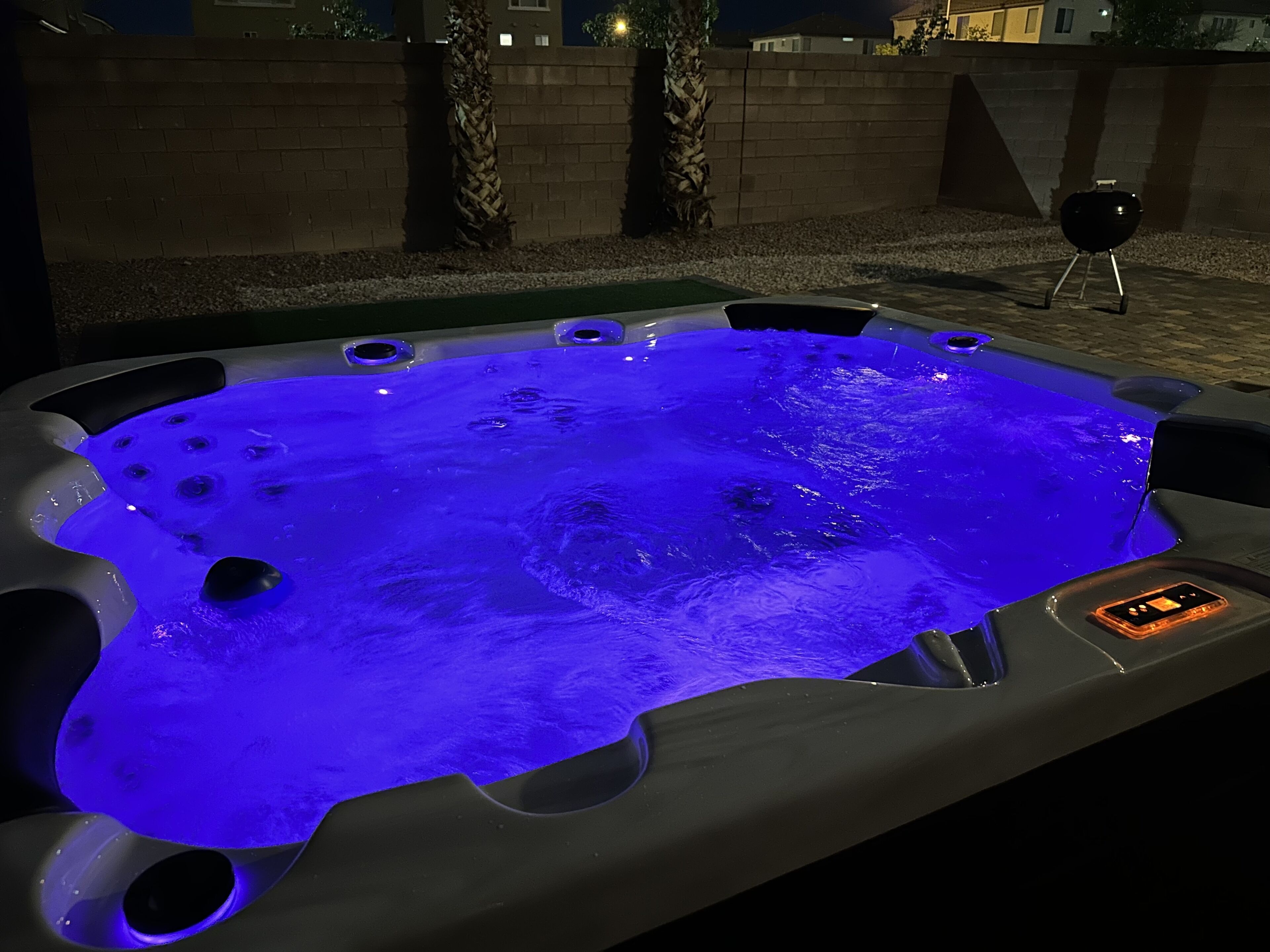A hot tub with a control panel and a grill in the background.