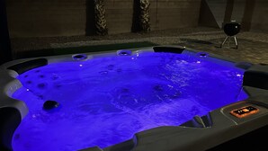 A hot tub with a control panel and a grill in the background.
