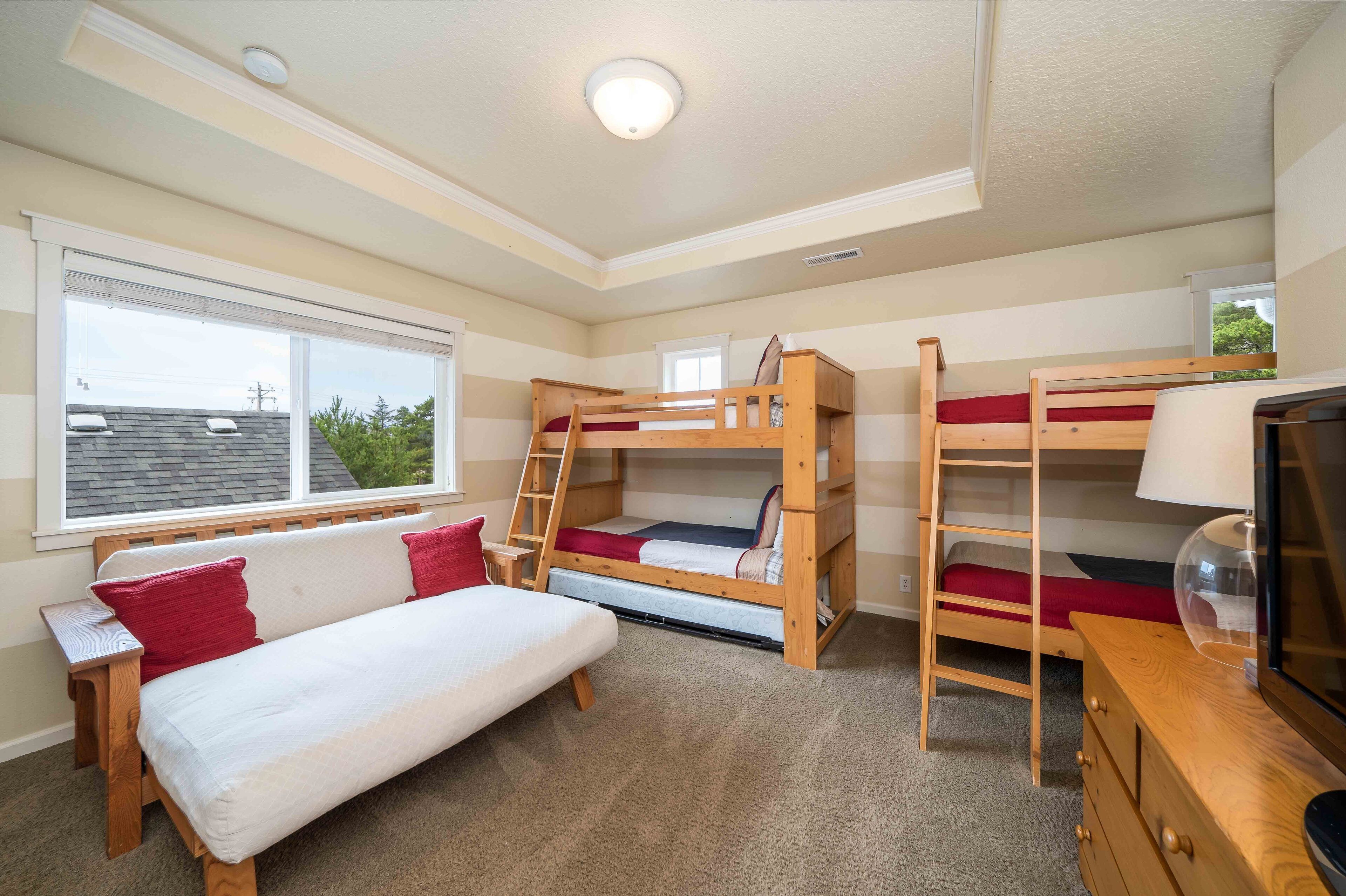 Une chambre avec un lit superposé, un bureau, une chaise et un téléviseur.