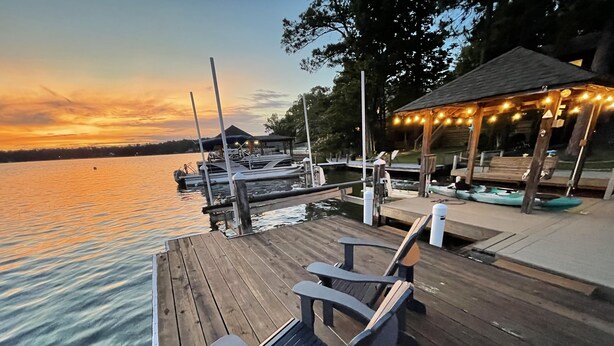 A wooden dock with chairs and a gazebo with string lights. - Lakefront Townhome with Stunning Sunsets – StillWaters on Lake Martin (Dadeville)