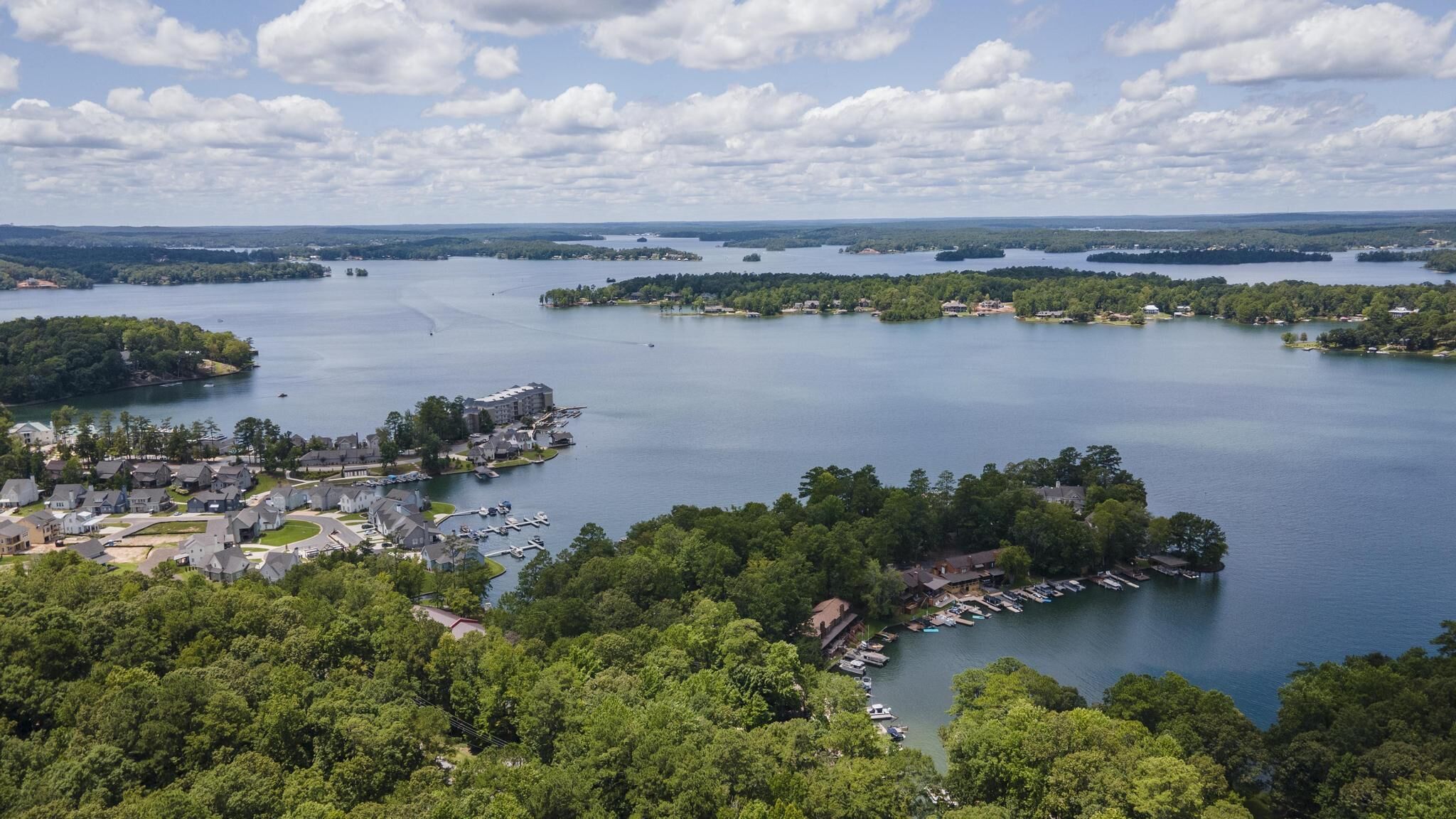 A lakeside community with residential buildings, docks, and boats.