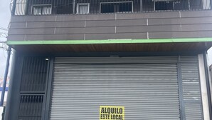 A building with a closed garage door, a green awning, and a sign that reads "ALQUILO ESTE LOCAL 8814 0505". - Cozy Downtown Alajuela / 5min from Airport (Alajuela)