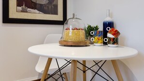 A dining table with a covered food display, a decorative bottle, and a framed picture on the wall. - Cosy Spacious 3+2 bedroom house , one bus to subway station (Toronto)