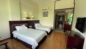 A hotel room with two beds, a TV, a desk, and a mirror. - Jinlang Mansion Hotel (Taishan)