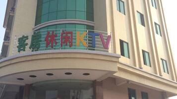 A hotel with a sign that reads '客房休闲KTV' indicating a room with a TV lounge.