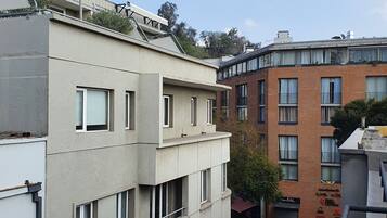 Un edificio de varios pisos con fachada plana, ventanas grandes y una terraza en la azotea.