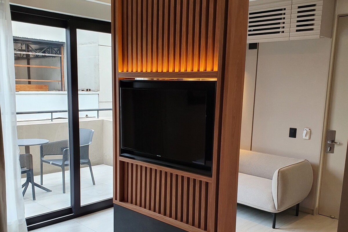 A modern living room with a built-in TV, a sofa, and a dining area.
