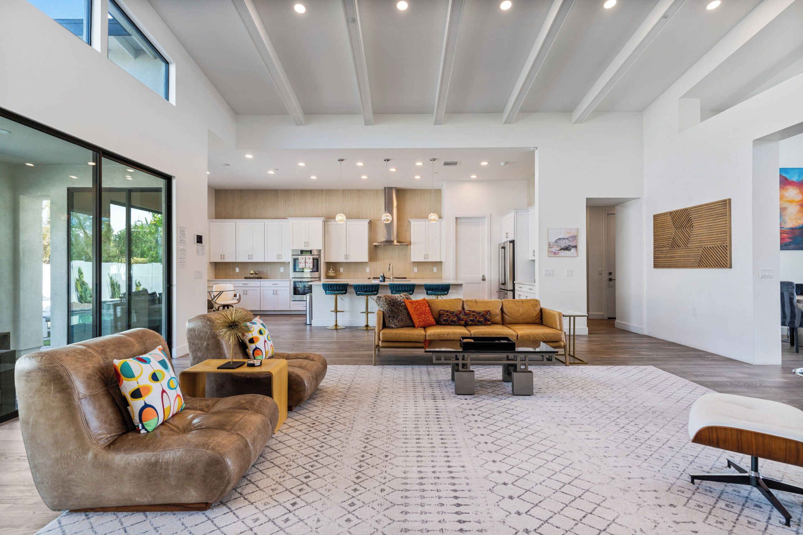 A spacious living area with a leather sofa, a coffee table, and a patterned rug.