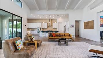A spacious living area with a leather sofa, a coffee table, and a patterned rug.