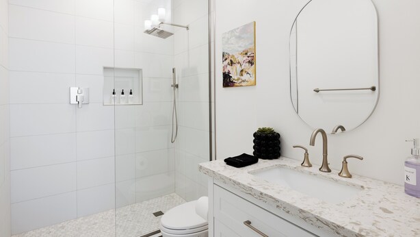 A modern bathroom with a shower, toilet, and sink.