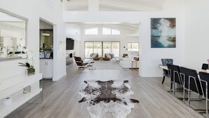 Un salón amplio con un gran tapete, muebles modernos y un cuadro en la pared.