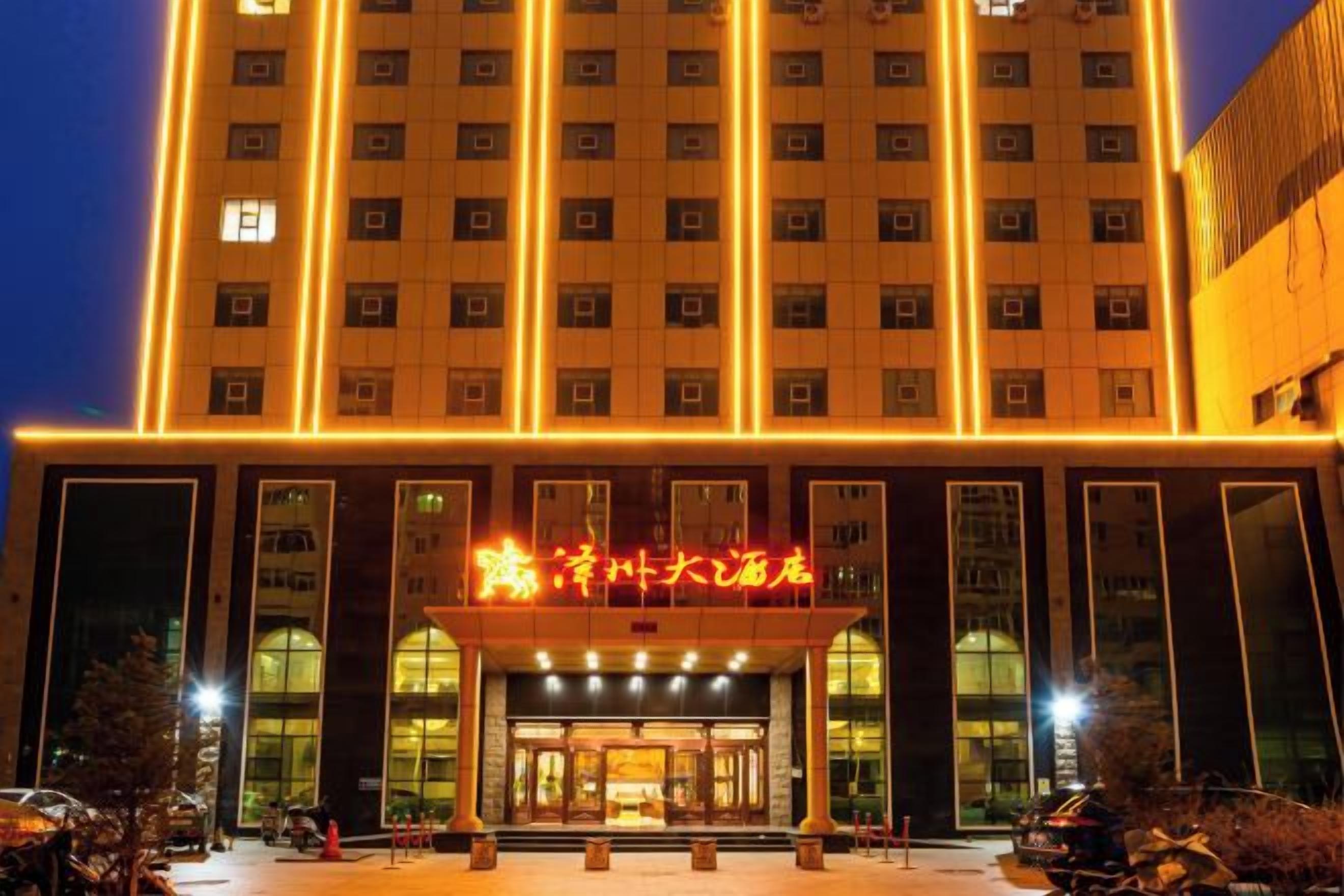 A multi-story hotel with a prominent entrance and illuminated signage.