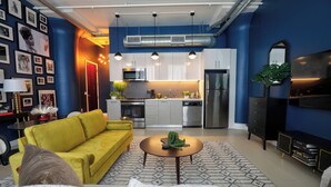 A modern living room with a yellow sofa, a round coffee table, and a patterned rug.