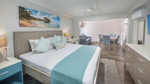 Habitación de hotel con cama, mesitas de noche, escritorio, silla, zona de comedor y aire acondicionado.