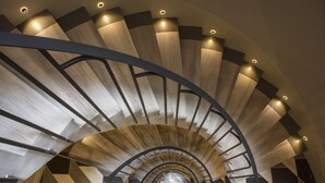 Eine Wendeltreppe mit modernem Design, bestehend aus Holz und Metall.