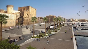 A waterfront promenade with palm trees, a castle-like building, and a marina with boats. - HUB NAPLES (Naples)
