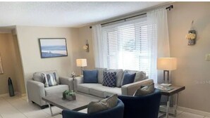 A living room with a sofa set, two armchairs, a coffee table, and a side table with lamps. - Heated Pool House On Golf Course/7 min from Beach - Discounted (Rotonda West)