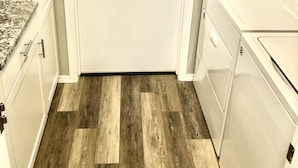 A compact kitchen with white cabinets, a granite countertop, and a wooden floor. - Beautiful newly remodeled 3 bed 2 bath foothills home.  No cleaning fees. (Albuquerque)