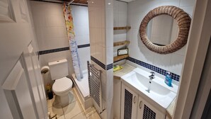 A bathroom with a toilet, bathtub, and sink.