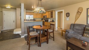 A spacious living area with a dining table, chairs, a sofa, and a coffee table.