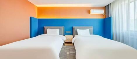 A hotel room with two beds, a nightstand, a wall-mounted air conditioner, and a window with curtains.