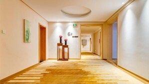 A hotel corridor with a carpeted floor, a wooden door, and a sign indicating room number 6F. - Lantian Hotel (Hulunbuir Ancient City) (Hulunbuir)