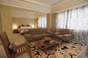A hotel room with a sofa set, a wooden coffee table, and a patterned carpet. - Lantian Hotel (Hulunbuir Ancient City) (Hulunbuir)