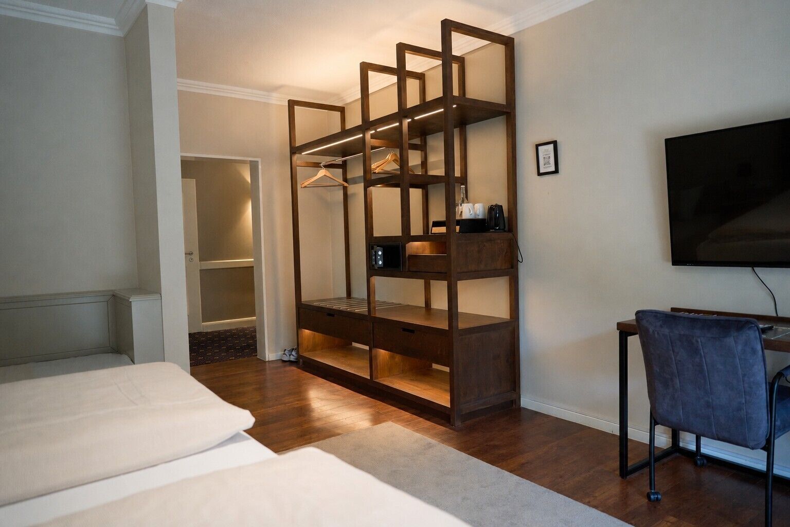Un dormitorio con literas, un escritorio con silla, televisor y vestidor.