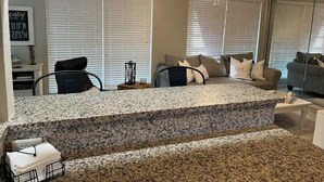 A modern living room with a kitchen island, large windows with blinds, and a ceiling fan. - Serenity Canal Cottage 2/2 on Gulf Access Canal!! (North Port)