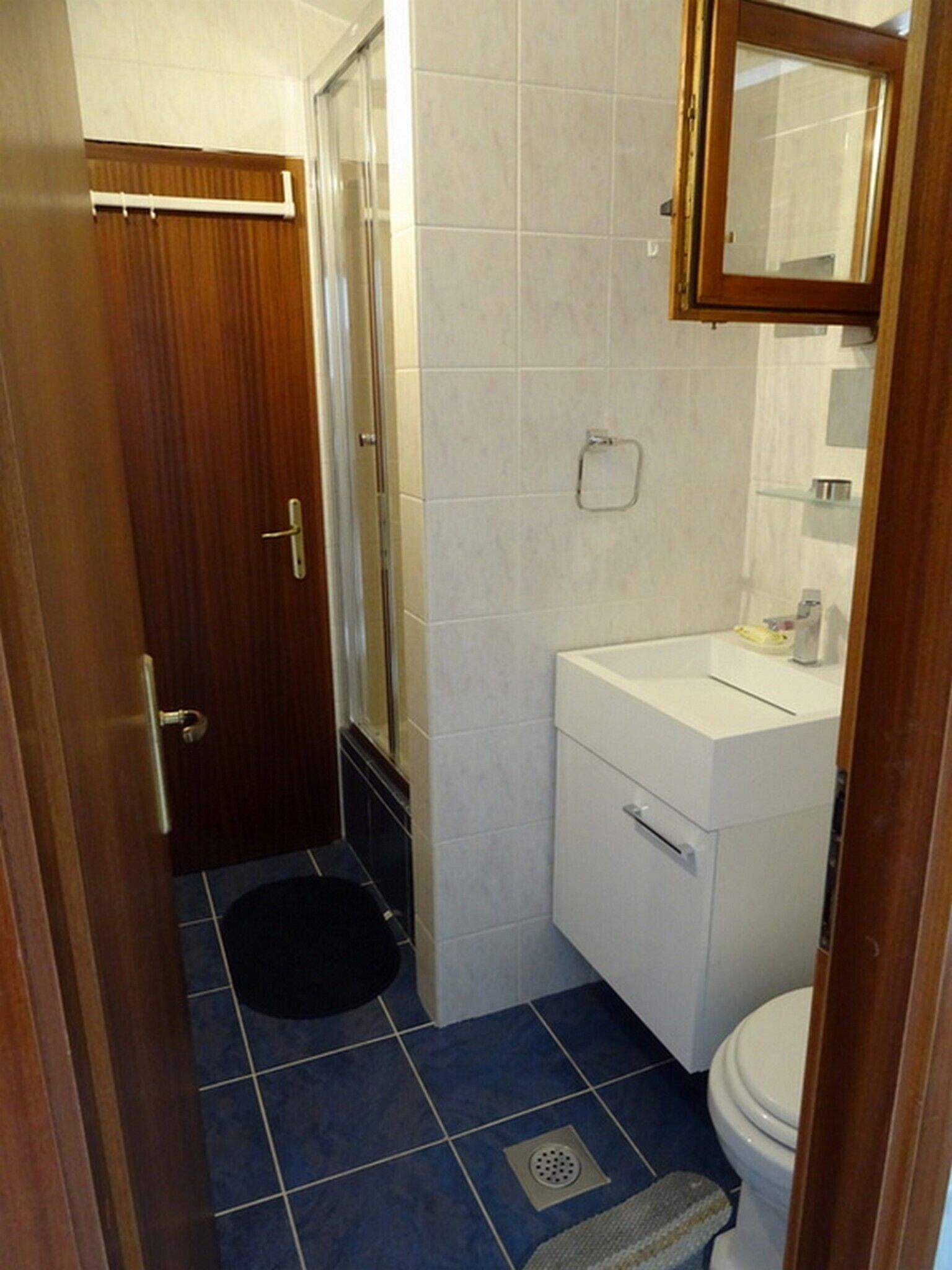 Une petite salle de bain avec des toilettes, un lavabo et une douche.