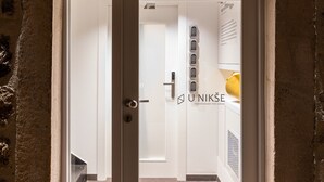 Una porta amb un rètol a dalt que diu "UNIKŠE".