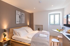 Ein modernes Schlafzimmer mit Bett, Nachttisch und Schreibtisch mit Stuhl.