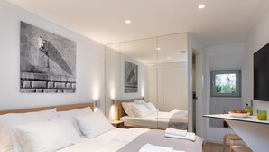 A modern hotel room with a large bed, a small desk, and a mirror. - Apartments u nikše - Studio Apartment (Dubrovnik)