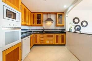 A kitchen with wooden cabinets, a built-in oven, and a tiled backsplash.