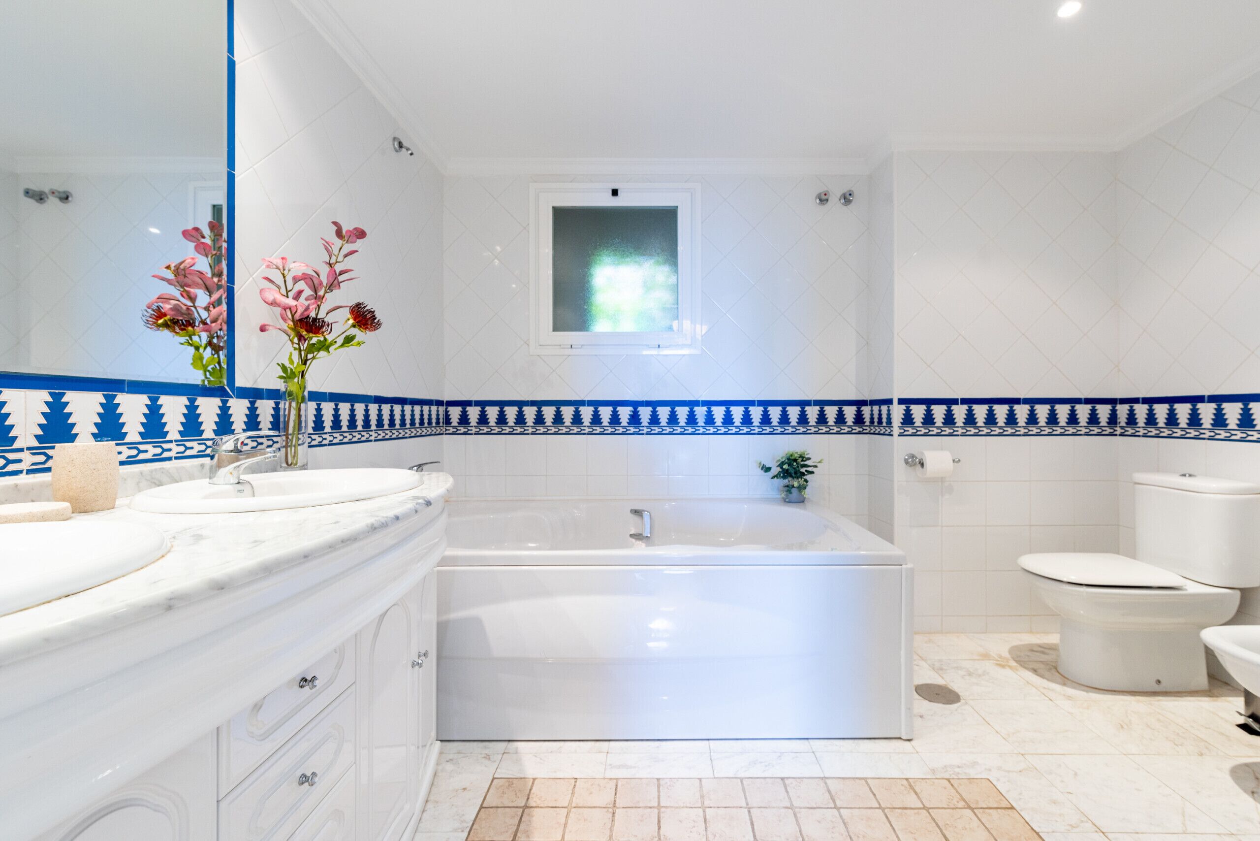 Une salle de bain avec une baignoire, des toilettes, un lavabo et un miroir.