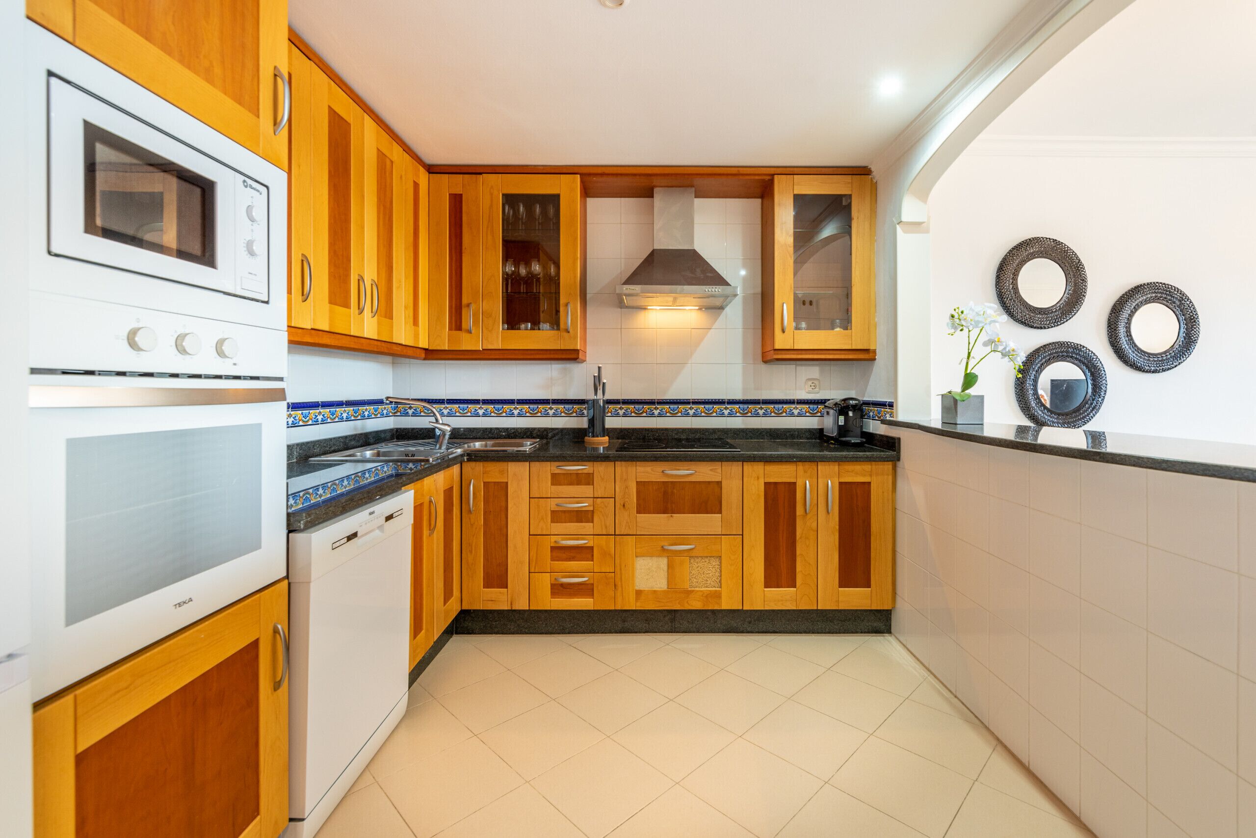 A kitchen with wooden cabinets, a built-in oven, and a tiled backsplash.