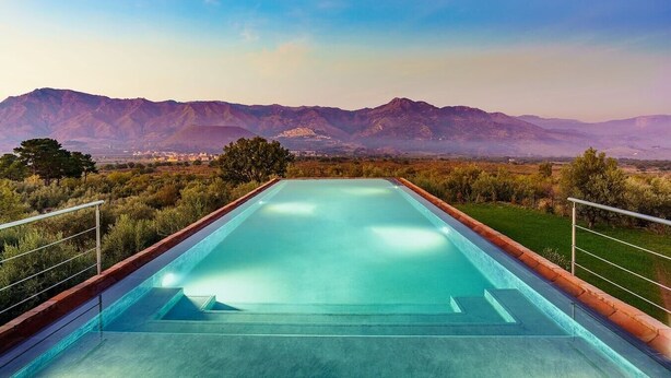 Ein rechteckiger Pool mit Blick auf Berge im Hintergrund.