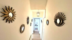 Un corridoio con pavimento in legno e pareti decorate da specchi a raggiera.