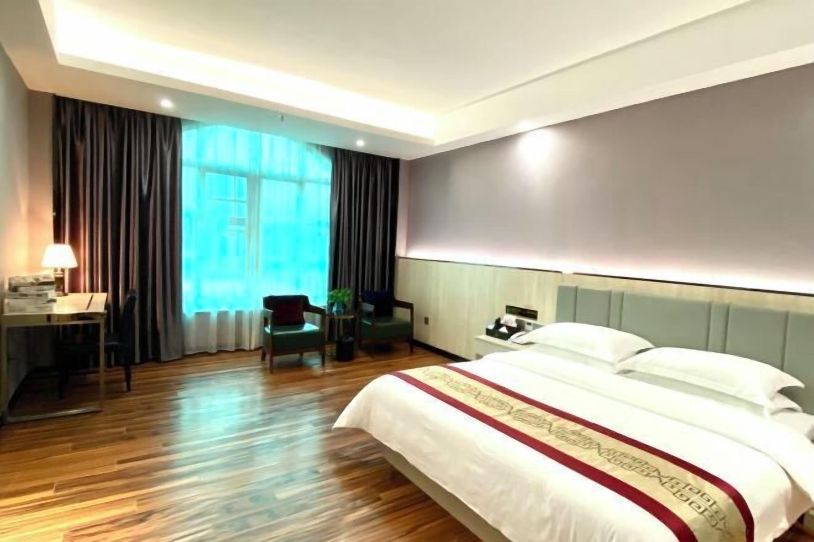 Una habitación de hotel con una cama grande, un escritorio y una silla.