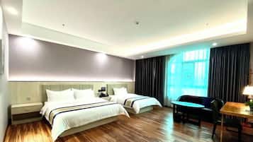 Habitación de hotel con dos camas, un escritorio, una silla y un ventanal con cortinas.