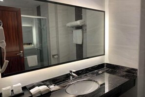 A modern bathroom with a large mirror, a sink, and a towel rack. - Bohai Hotel （Taishan Chonglou) (Taishan)