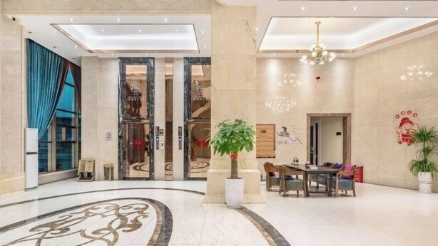 A spacious lobby with a marble floor, a reception desk, a dining area, and a staircase leading to an upper level. - Bohai Hotel （Taishan Chonglou) (Taishan)