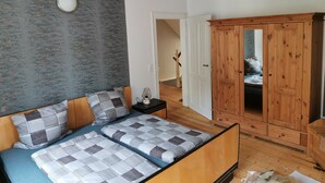 Een slaapkamer met een bed, een kledingkast en een wand met een structuur.