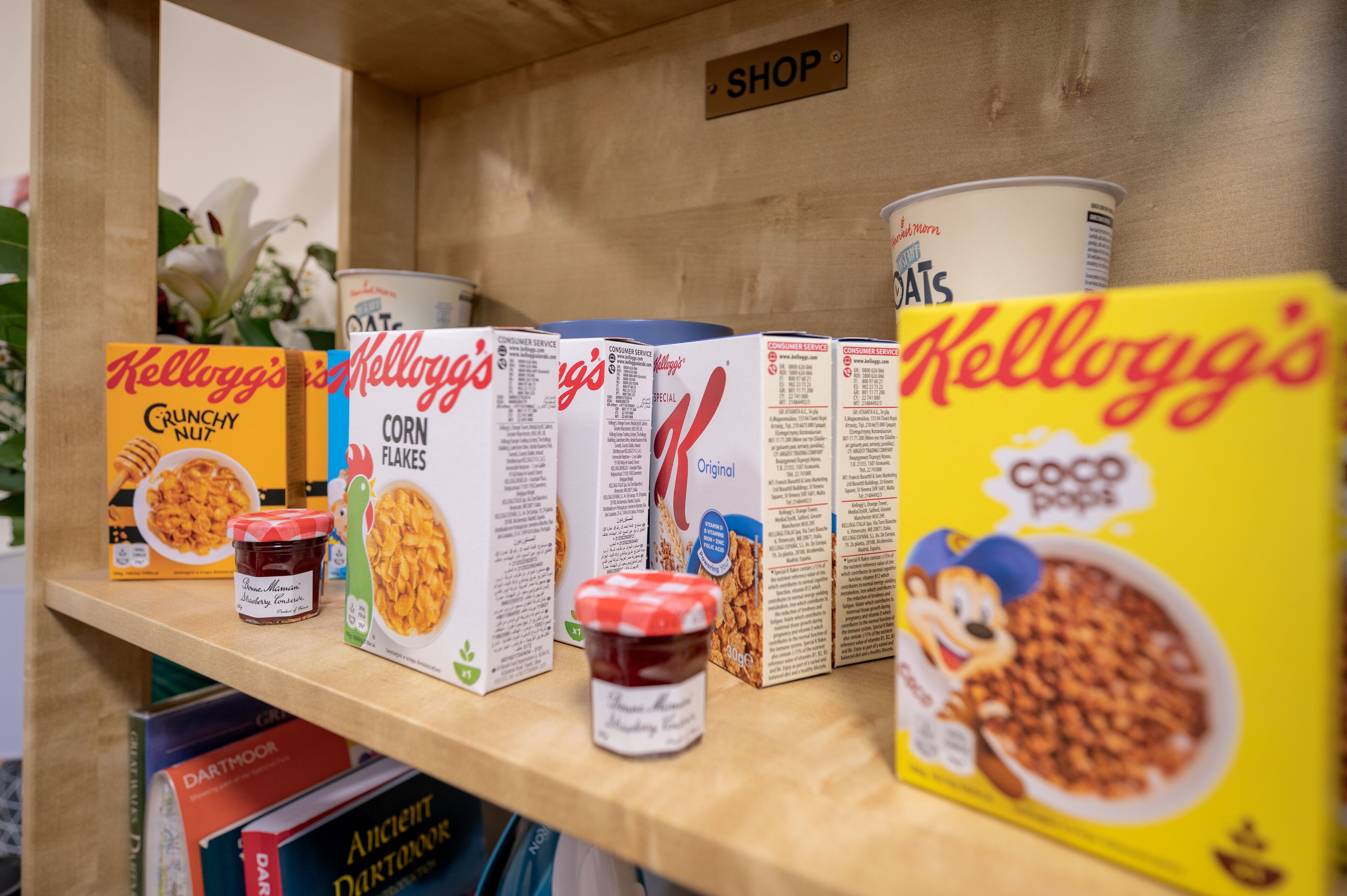 Cereal boxes and jars on a shelf.